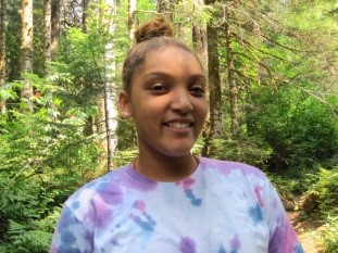 Jacynta Myles-Guilford poses in the woods on a hike for a picture