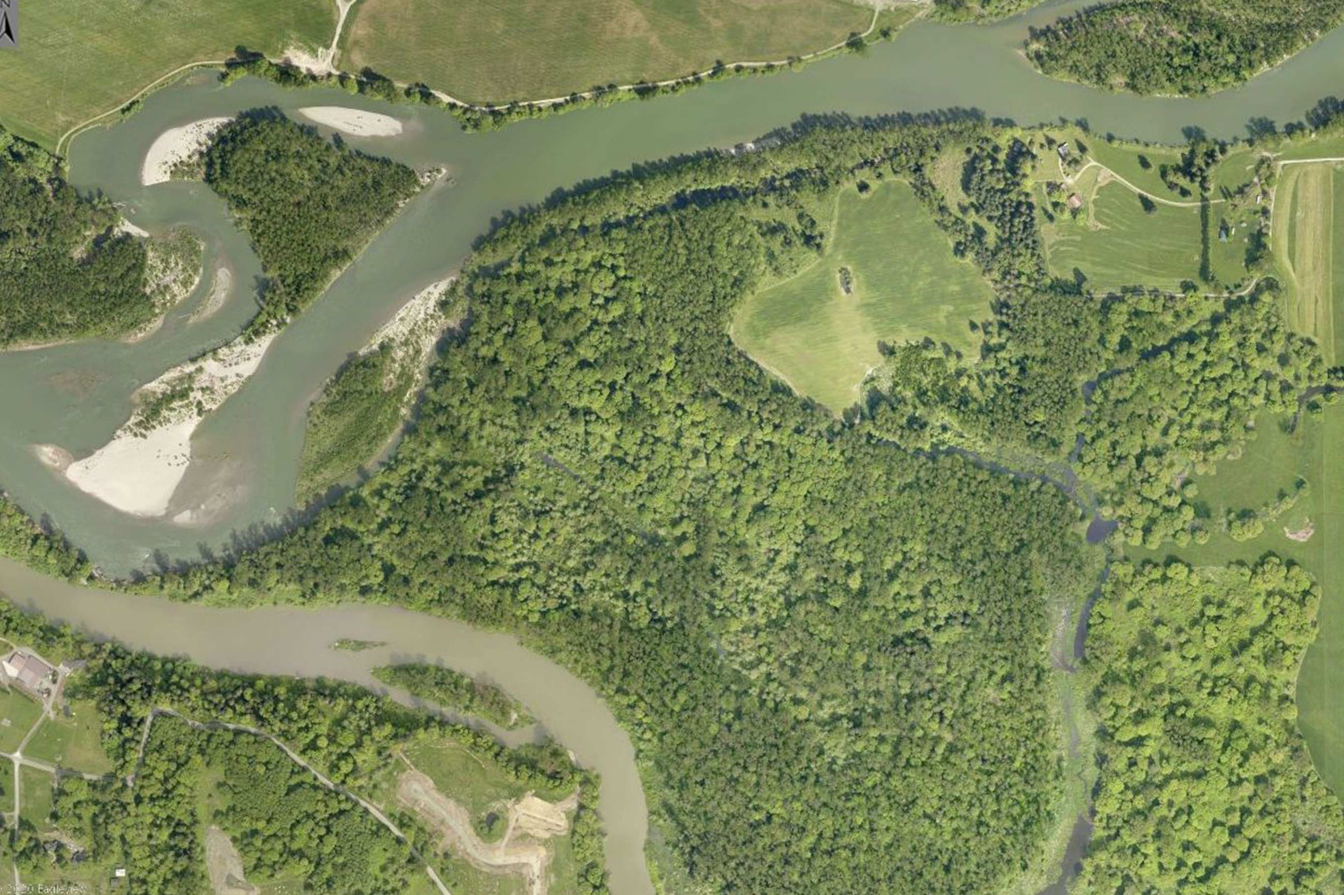Tualco Valley aerial meandering waterways through green farmland and a large wooded area with tracings of smaller tributaries 