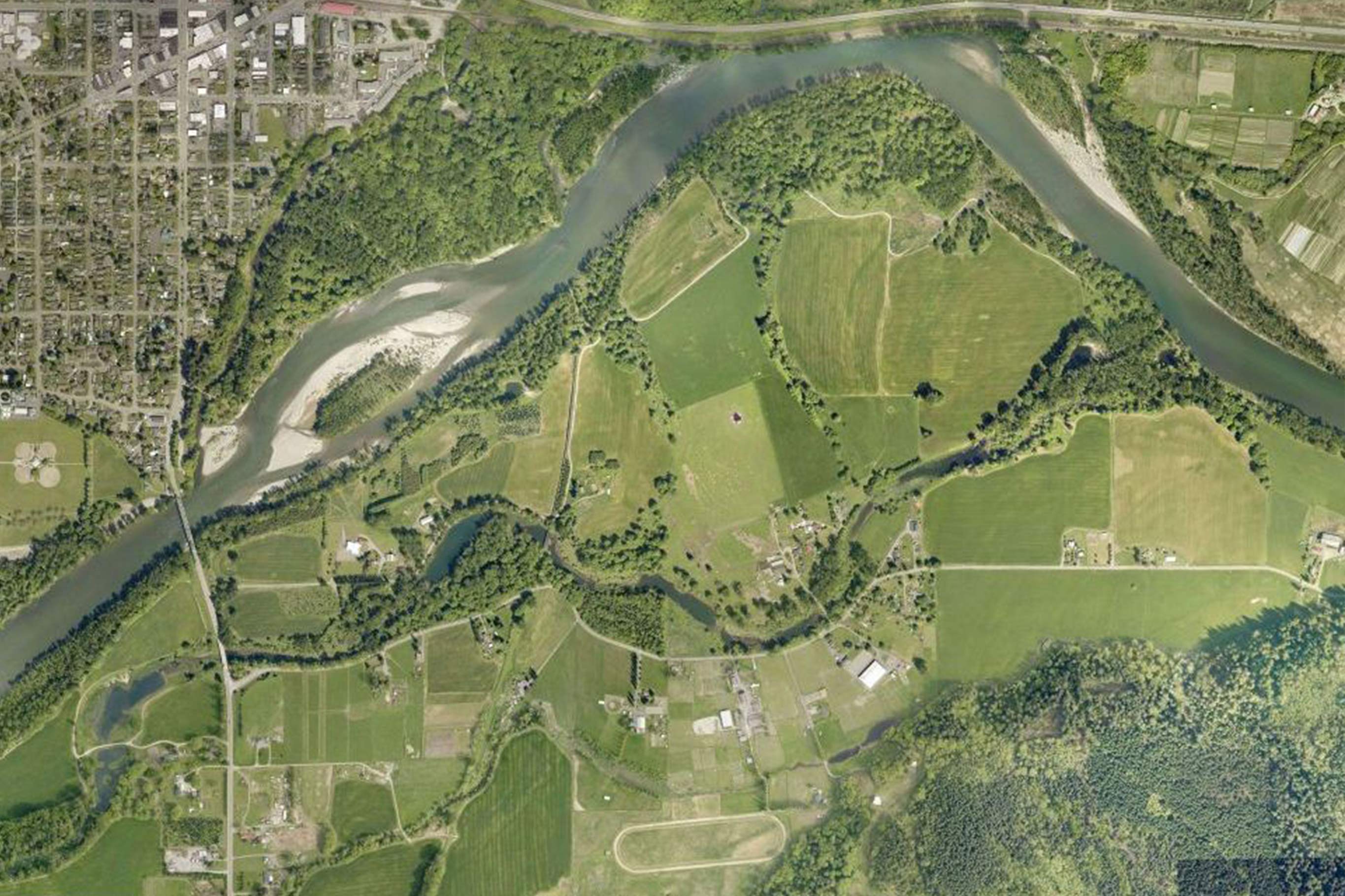 Tualco Valley aerial of rivers tracings through farmlands, wooded areas, and small neighborhoods nearby